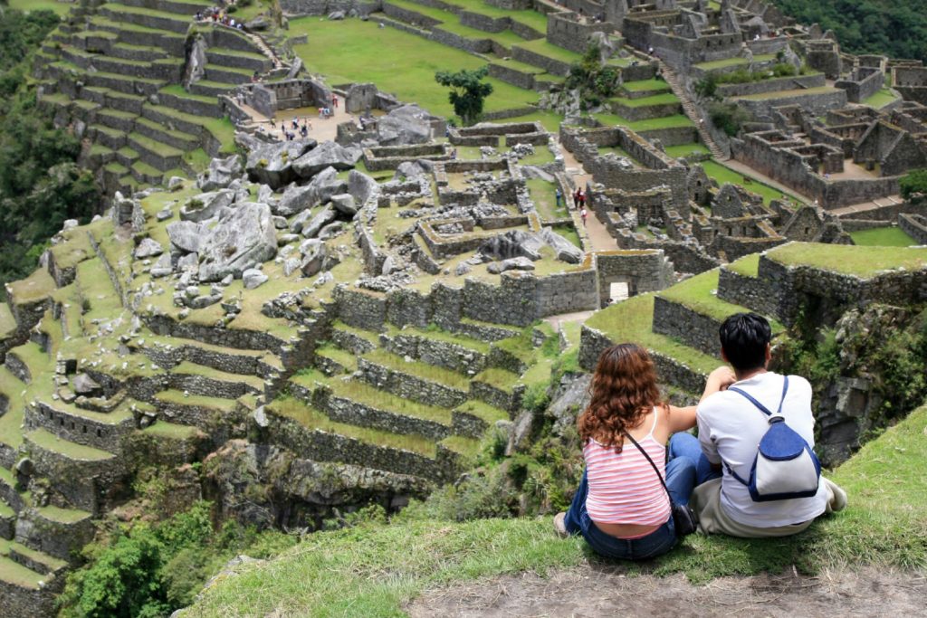 Young couple looking the famous Machu Picchu / Onfokus, Getty Images