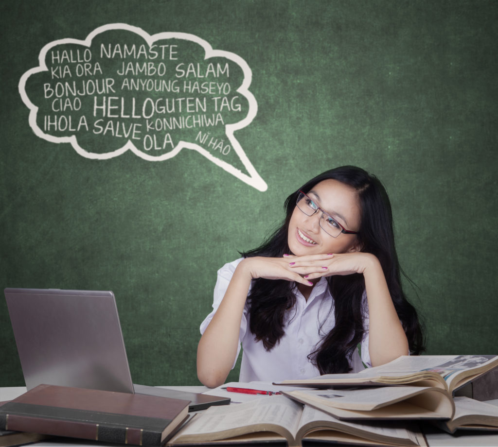 Portrait of female high school student learns foreign language and looking at cloud speech in the classroom / Deposit Photos