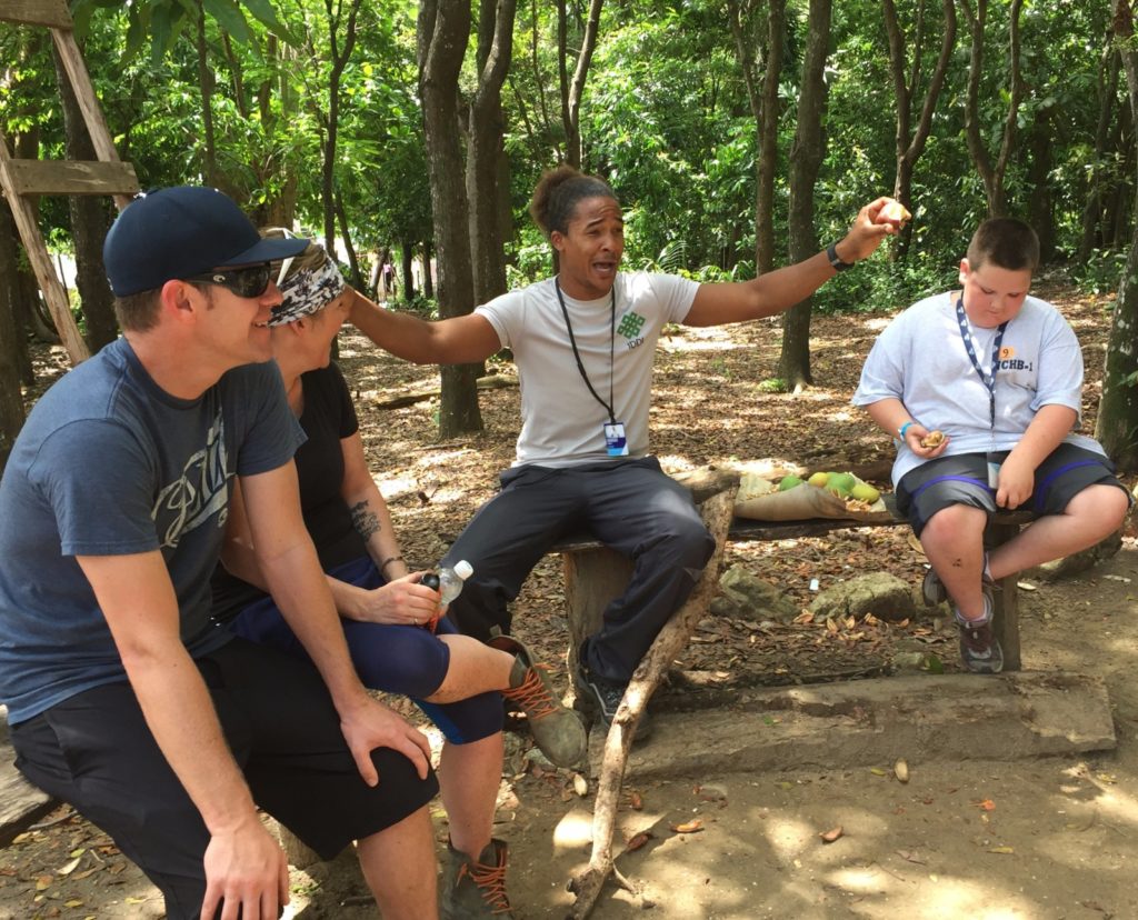 Our host in the Dominican Republic explains the process of finding seedlings, planting them for greenhouse growth, then transplanting them on the mountainside / Melody Moser