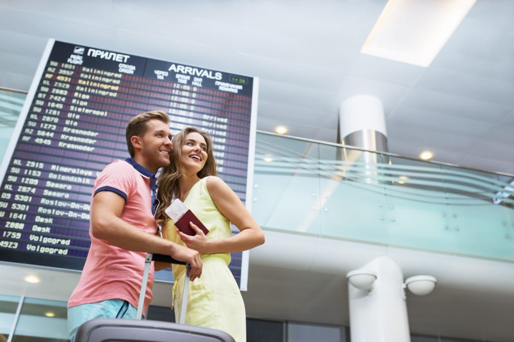 Smiling couple at the airport by Deklofenak, Deposit Photos