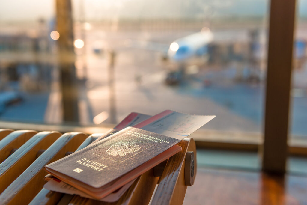 Tickets and passports with an airplane in the background.