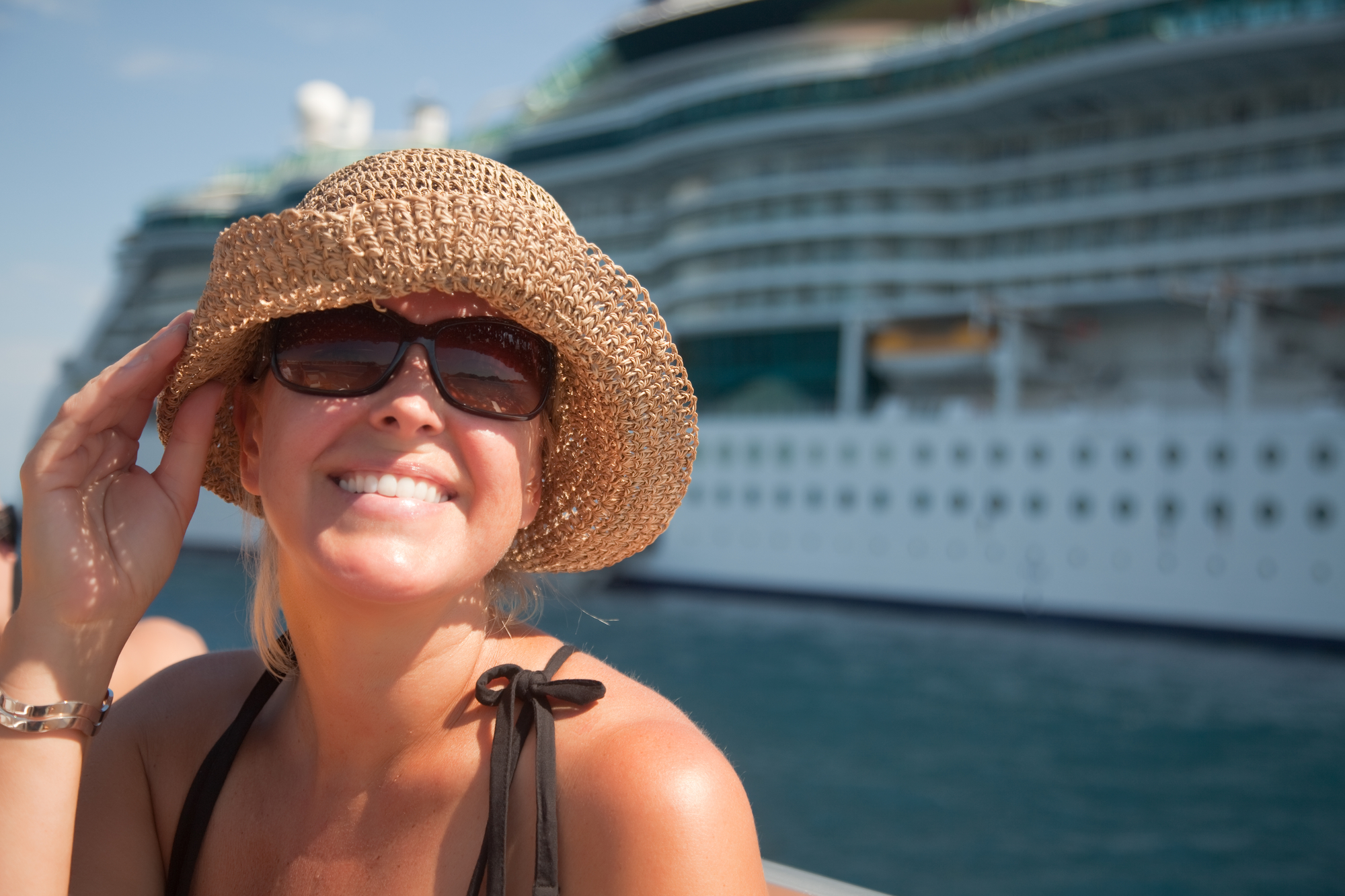 Woman on Tender Boat with Cruise Ship in the Background / By Feverpitch, Deposit Photos