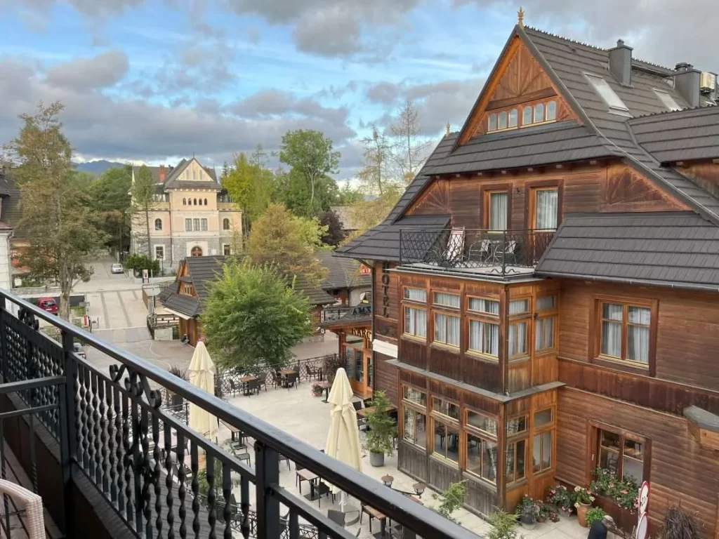 Balcony view of traditional wooden architecture and quiet streets in Zakopane, Poland, an affordable off-peak holiday travel deals destination near the Tatra Mountains.